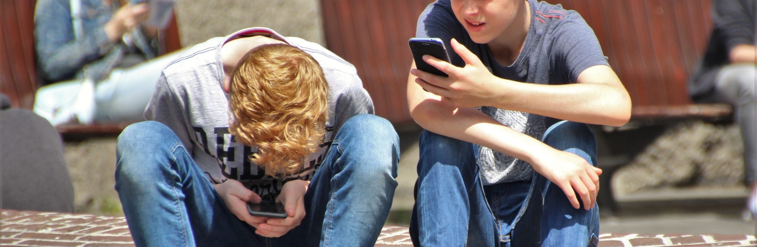 2-boy-sitting-on-brown-floor-while-using-their-smartphone-159395