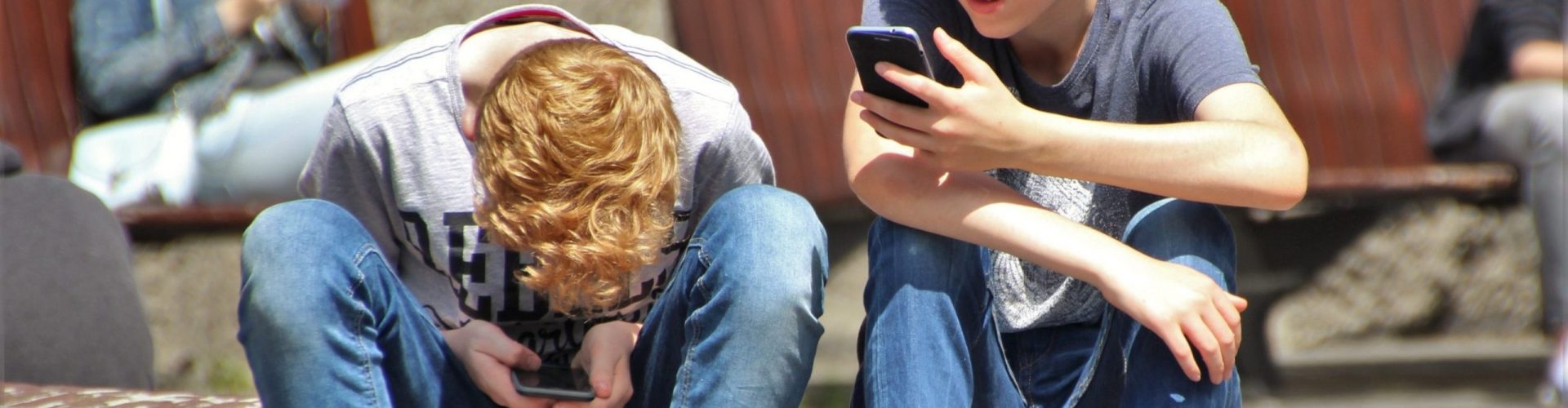 2-boy-sitting-on-brown-floor-while-using-their-smartphone-159395