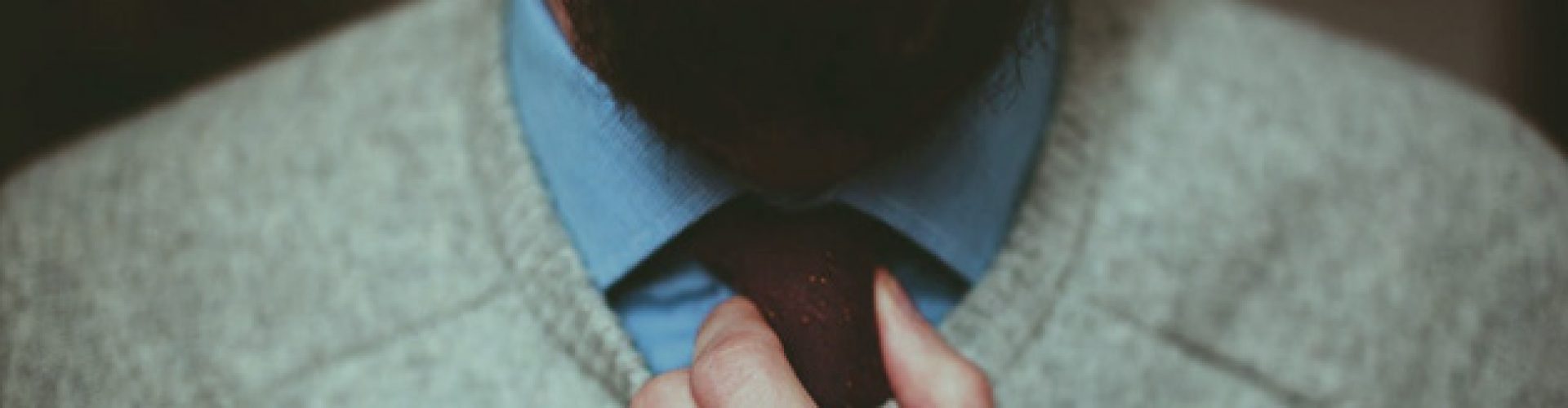 man adjusting his tie